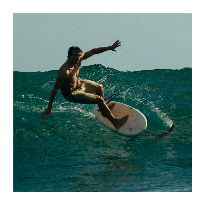 Surfeur exécutant un virage serré sur une vague avec la F-ONE ROCKET SURF PRONE