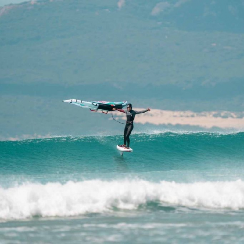 Rider sur une vague avec l'aile de wingfoil Reedin SuperNatural 2025