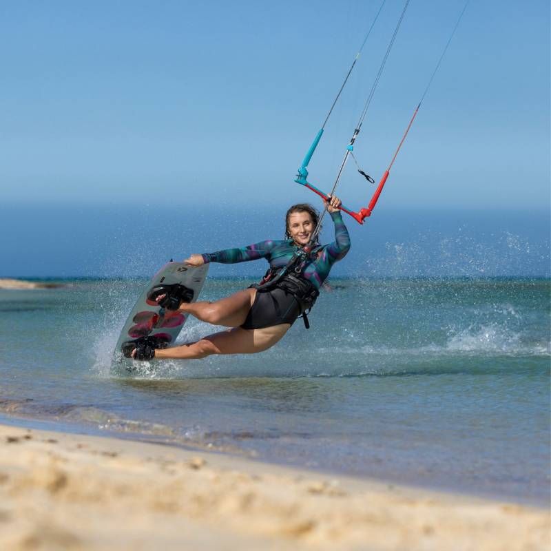 Barre Duotone Trust Bar 2026 utilisée par une kitesurfeuse sur l'eau 
