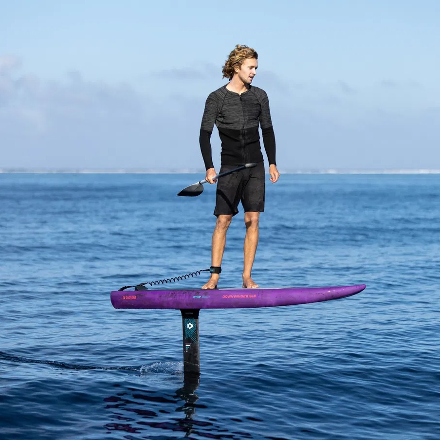 Rider en SUP foil sur planche DUOTONE Downwinder SLS 2024 sur mer calme