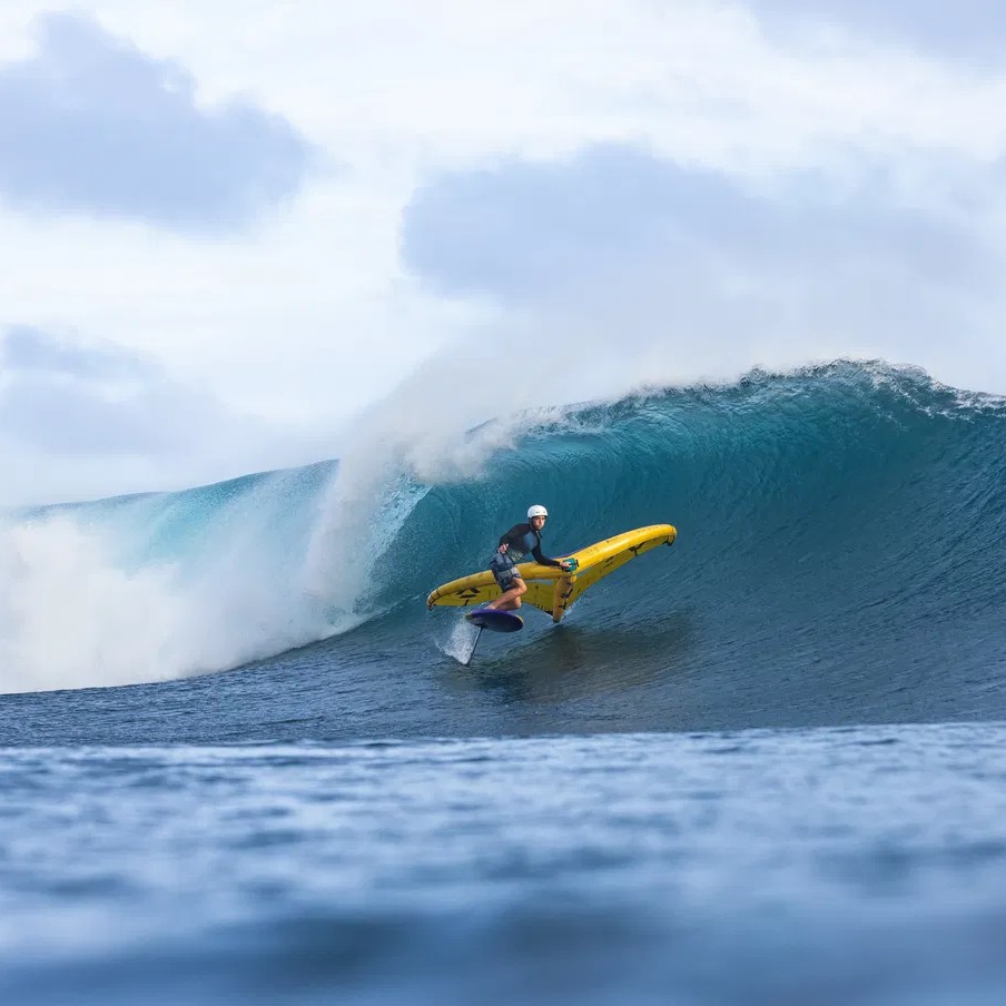 Rider en wingfoil avec la planche Duotone Sky Surf SLS 2024 en pleine courbe sur une vague à Tahiti