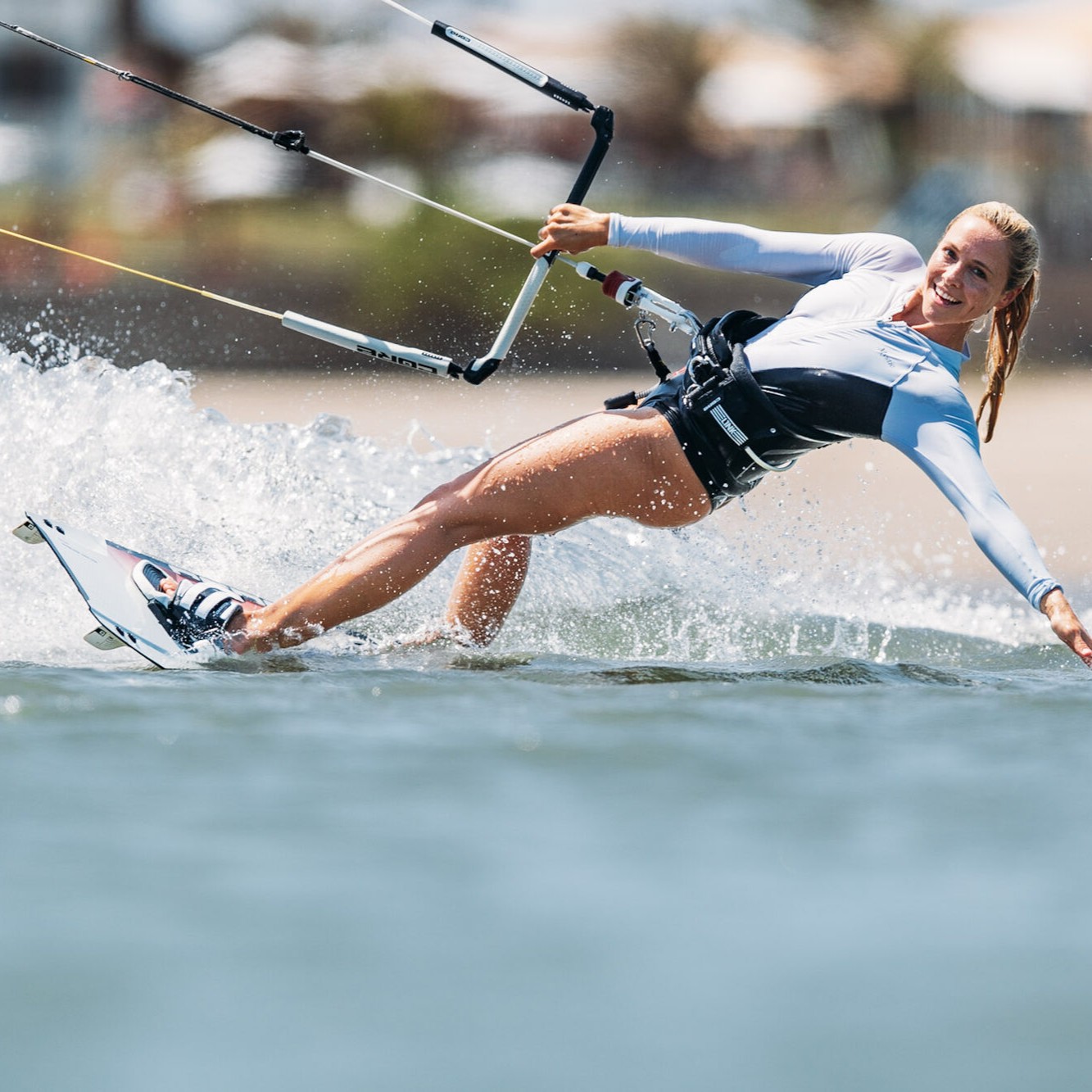 Kitesurfeuse souriante avec CORE Fusion 7, carving sur l’eau