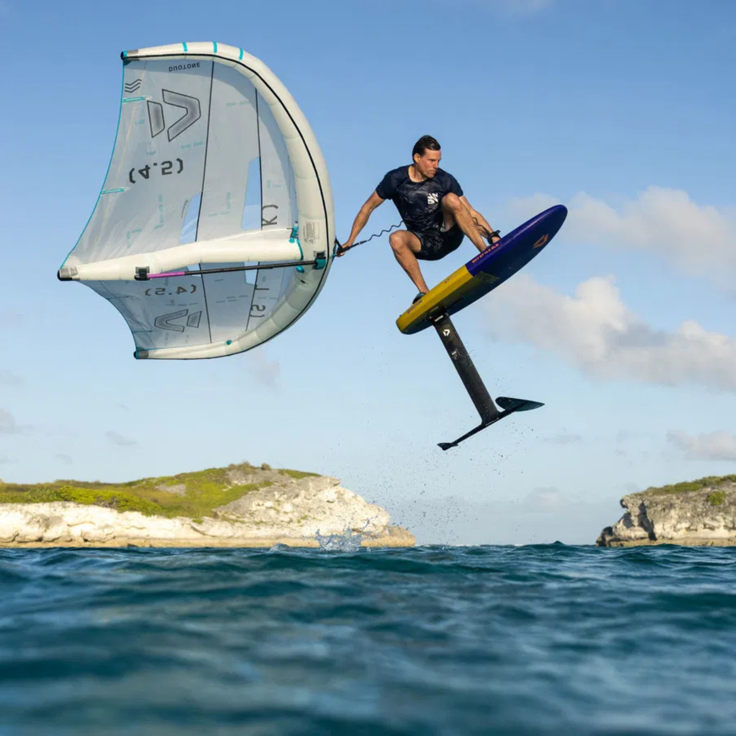 Rider en action avec la Duotone Whizz SLS 2025 en wingfoil, saut aérien avec aile wing.