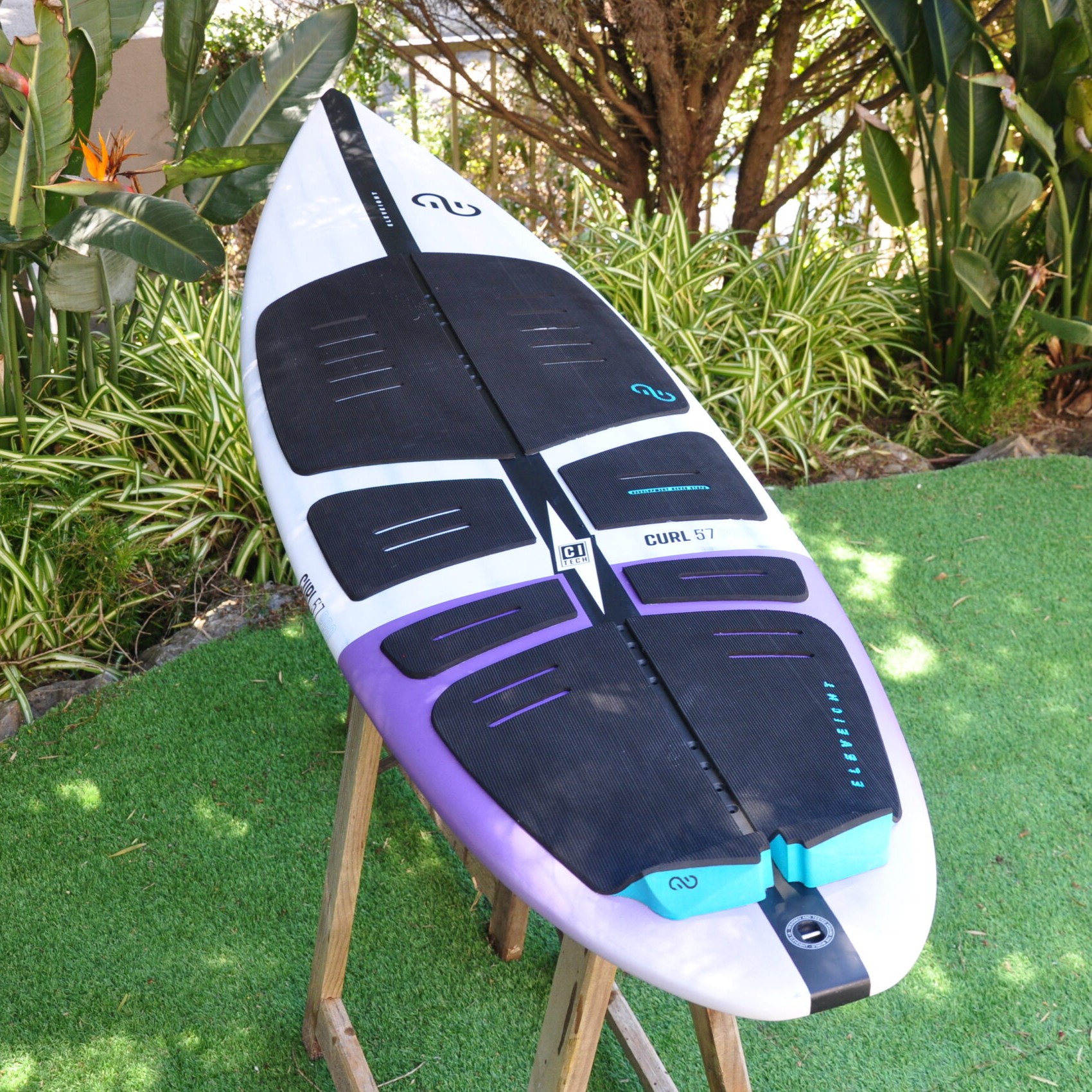 Planche de surf Curl Pro 2025 Eleveight exposée en extérieur sur support bois