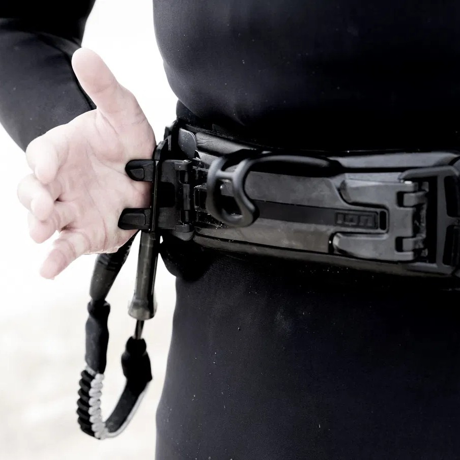 Un rider s’équipe du harnais ION Riot Curv 2025 noir – harnais rigide pour kitesurf homme
