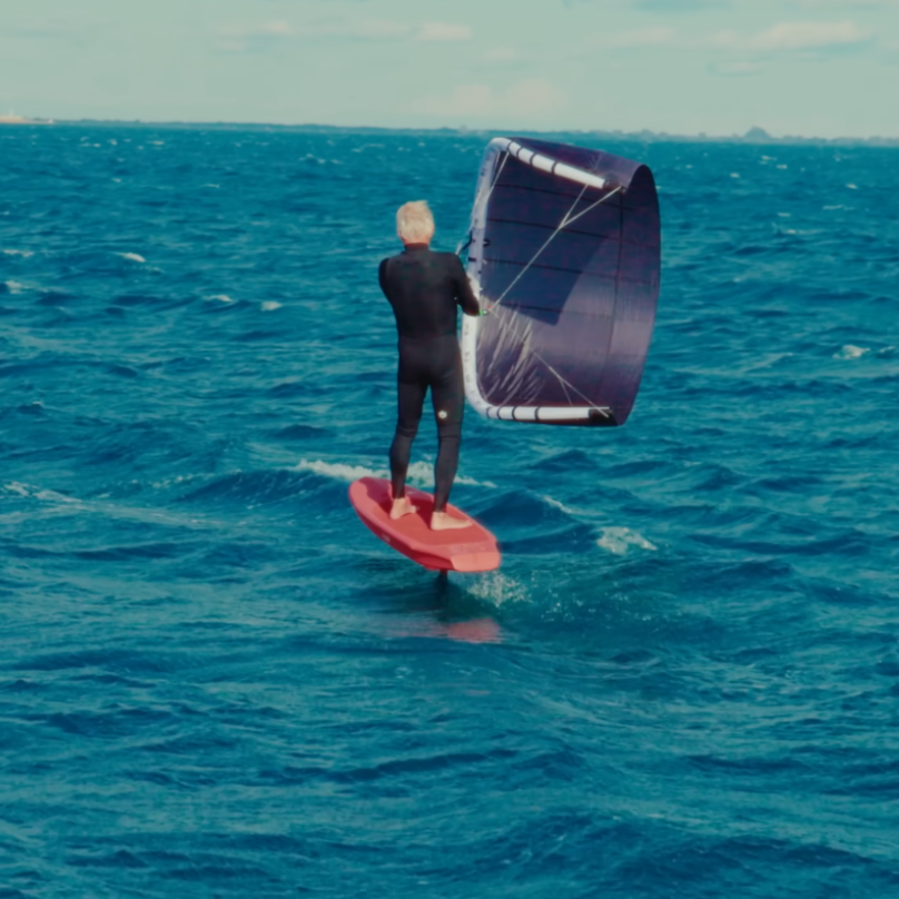 K-Wing foil sur mer agitée – glisse sportive avec aile noire et planche rouge