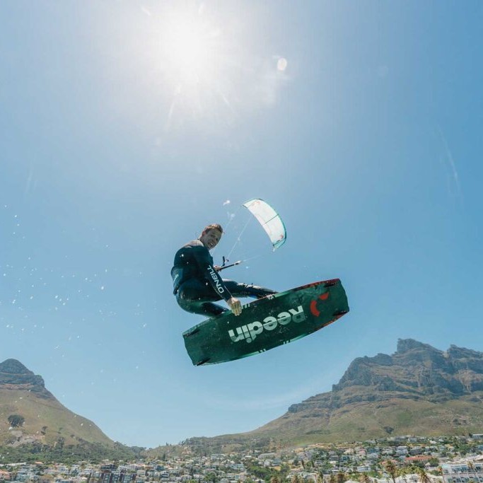 Rider en kitesurf en plein saut sous le soleil avec aile Reedin WhisperModel 2025 – aile de kite lightwind réactive et légère