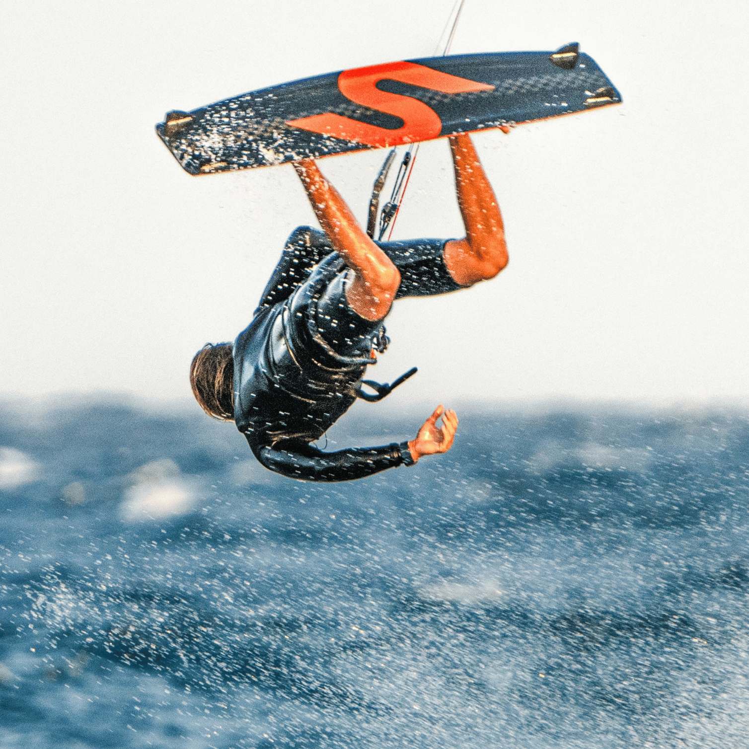 Rider effectuant un saut avec la planche de kitesurf Slingshot Formula V4 2025 au-dessus de l’eau