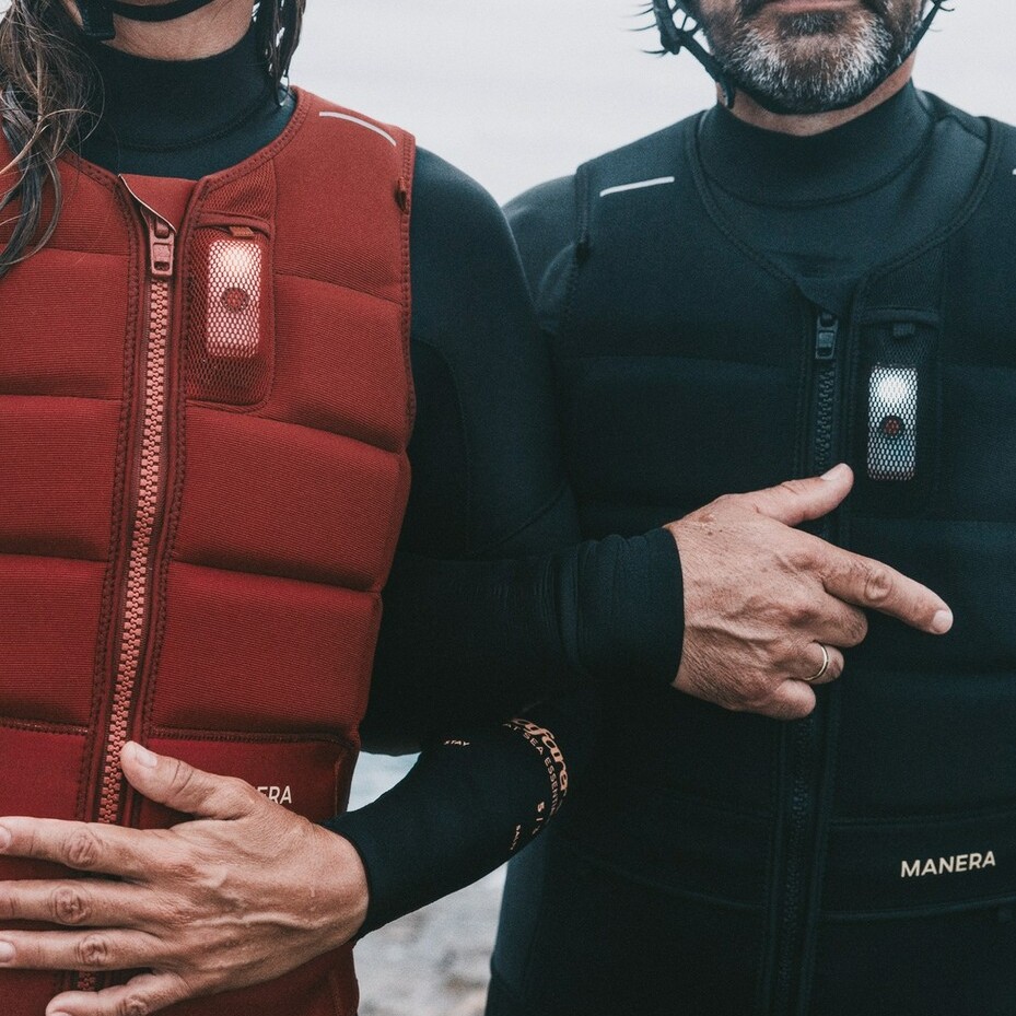 Riders portant la veste MANERA Vagabond Impact 2025 en rouge et noir, avec lampe de sécurité visible à l’avant