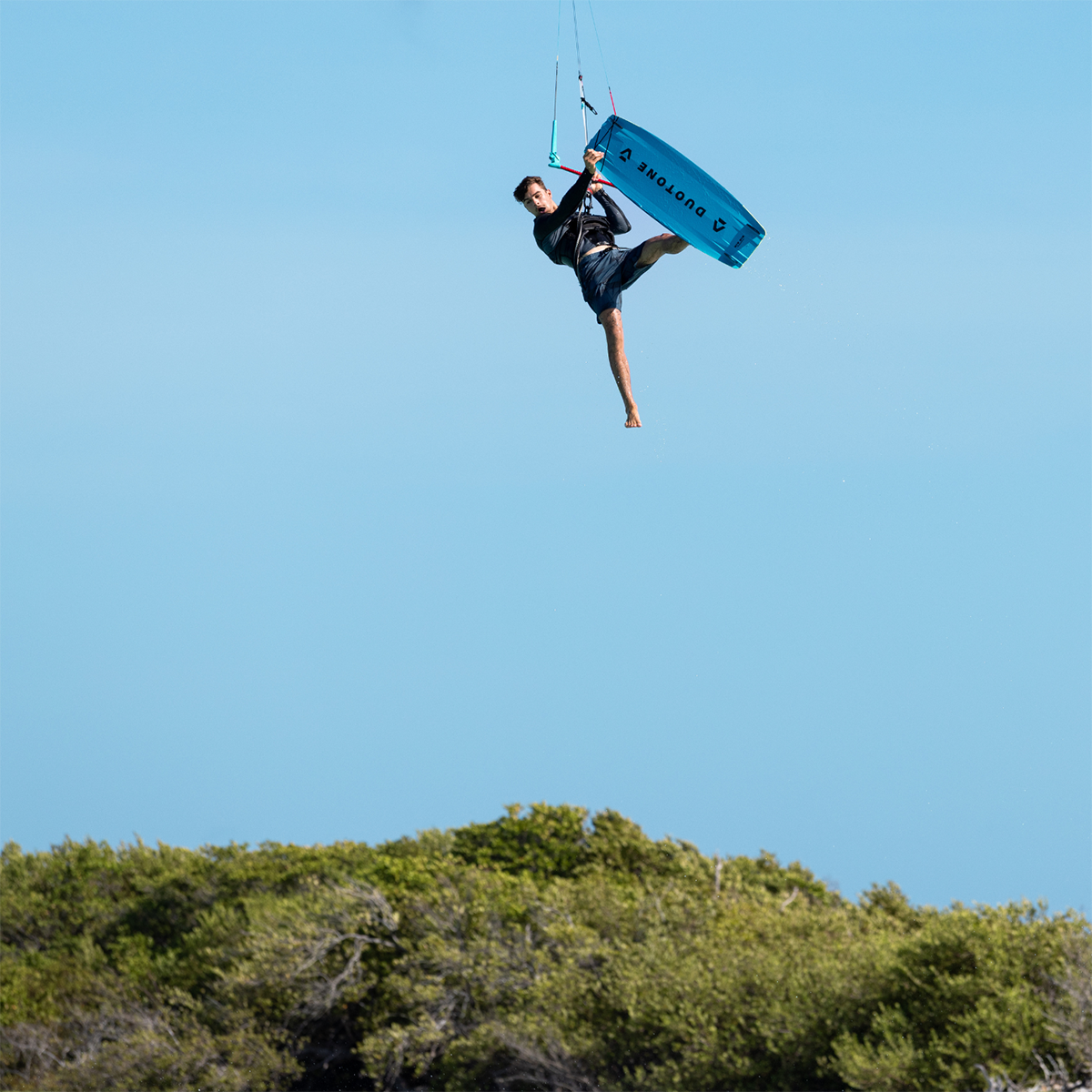 Kitesurfer réalisant un saut Big Air avec planche Duotone, figure en hauteur